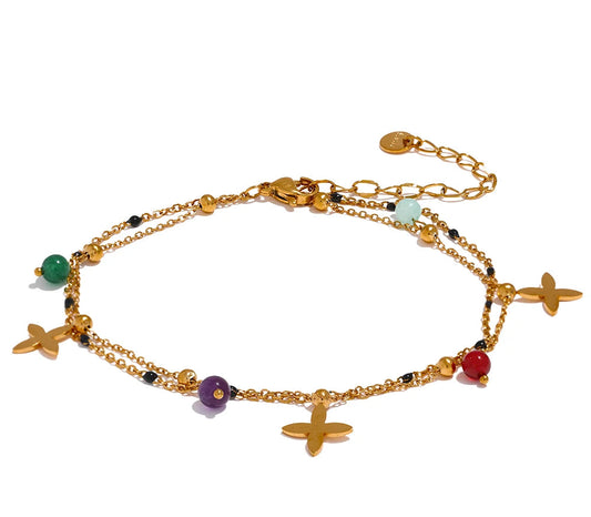 Gold anklet with colorful beads and charms on a white background, 